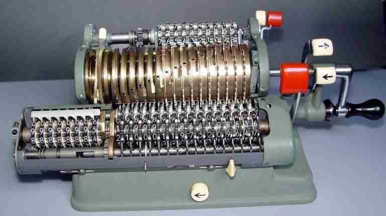 A vintage mechanical calculator with multiple rotating numeral drums and a crank handle. bet accumulator calculator