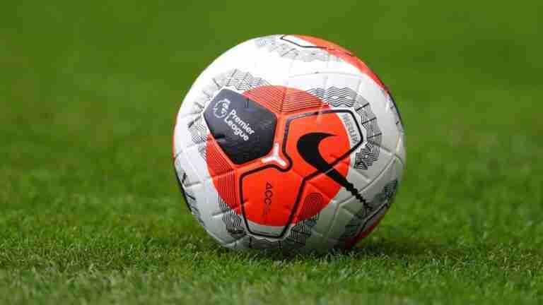 A close-up view of a modern, geometric-patterned soccer ball on a lush green pitch, ready for match play. best football betting sites