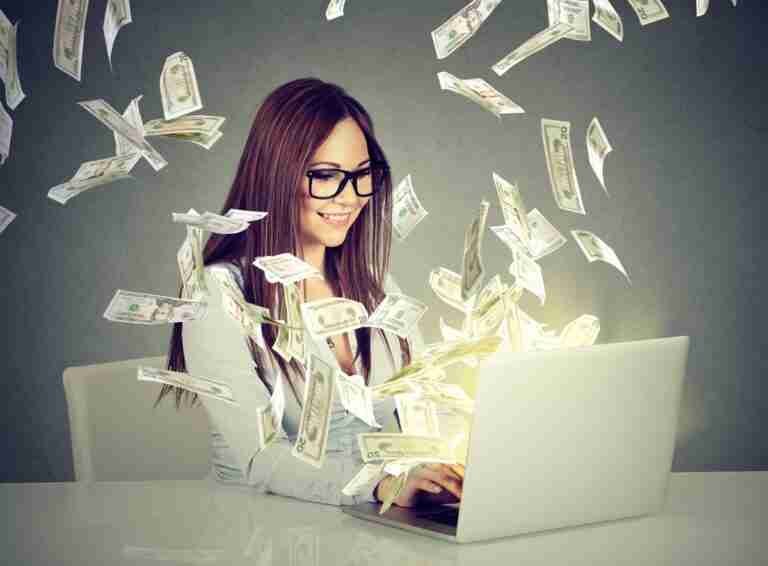 A content entrepreneur working on her laptop as money flies around, symbolizing financial success from her online business ventures. how much can you make from matched betting