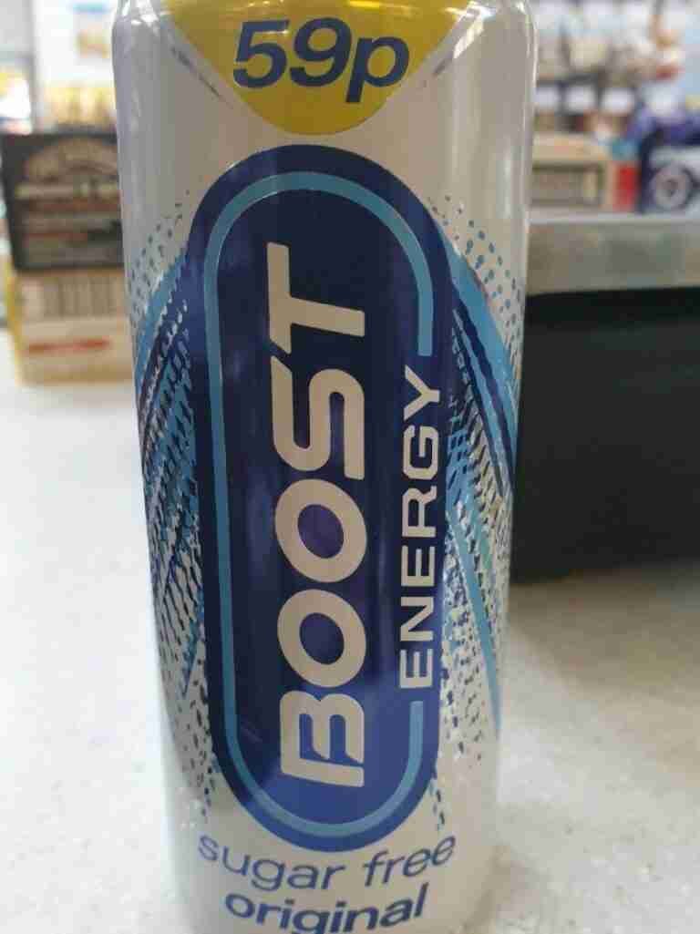 A can of "boost energy" sugar-free original flavor energy drink with a price tag of 59 pence, displayed on a sales counter with various items in the background. matched betting price boosts.